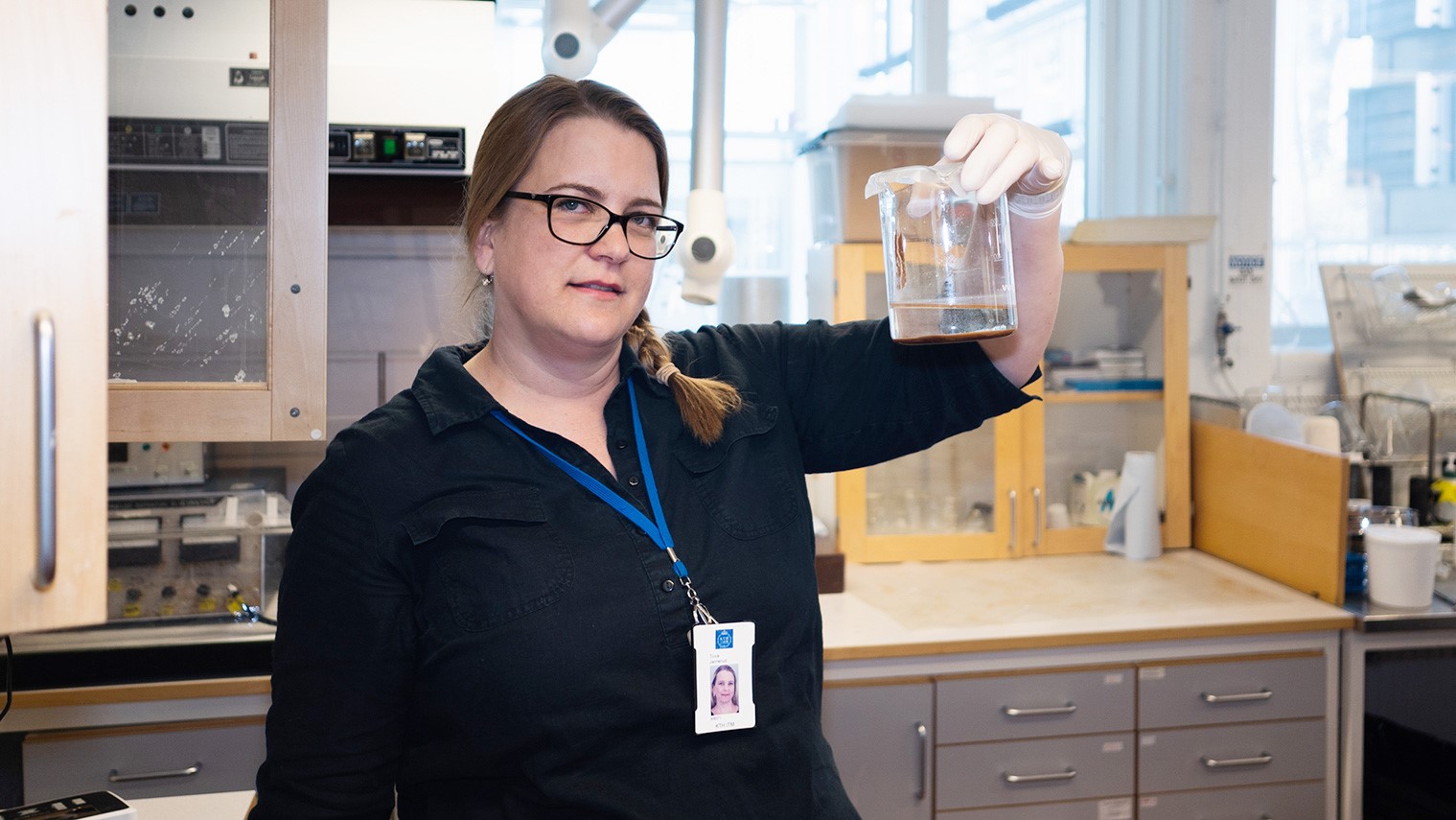 Woman in lab holding a lab glass