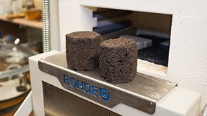 Briquettes in front of a blast furnace.